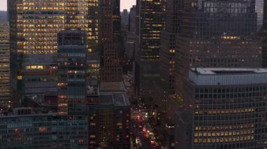 Karanlık New York 'un üzerine çöker, Manhattan' da sıcak bir parıltı bırakır aydınlanmış binalar ve hava perspektifinden trafik.
