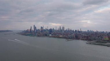 Hudson Nehri 'nin üzerinde yükselen Manhattan şehir merkezinin gökyüzü manzarası, Hudson Yardları' nın da içinde bulunduğu gri bulutlar kentsel mimari manzarayı vurguluyor..