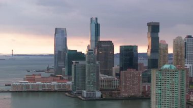 Jersey City gökdeleni günbatımı renkleriyle parıldıyor. Hudson Nehri 'nin sularında New York' un önünde yansıyor..