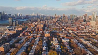 Brooklyn 'deki Williamsburg yerleşim sokağının hava görüntüsü şehrin sonbahar manzarası boyunca Manhattan ufuk çizgisini gözler önüne seriyor..
