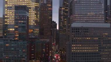 Parlak Manhattan gökdelenleri alacakaranlık gökyüzünde parıldıyor, geniş şehir manzarası ışıklandırmasıyla geniş bir manzara yakalıyor..