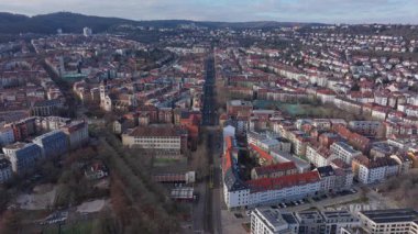 Almanya 'nın Stuttgart kentsel manzarasının üç ayaklı görüntüsü, merkez cadde boyunca hareket eden bir tramvayı gösteriyor..