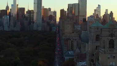 Hava görüntüleri, San Remo yakınlarında gün batımının ışığında parlayan Central Park 'ı yakalıyor. Manhattan ufuk çizgisi ufka uzanırken, cadde boyunca trafik ilerliyor..