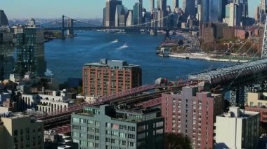 New York 'ta East River' ı geçen feribot Manhattan 'a yaklaşırken, Williamsburg köprüsü ve ön planda belirgin bir Domino Square Condominium görünmektedir..