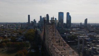 Queensboro Köprüsü üzerinde ilerleyen hava manzarası ve Queens borough 'un alçak yerleşim binaları, arka planda Long Island City' nin gökdelenleri..