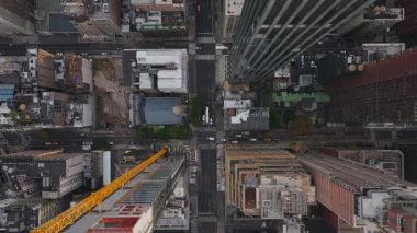 Havadan bakıldığında, canlı bir New York caddesi üzerinde dönen bir inşaat vincinin canlı şehir manzarasını ve metropolde devam eden gelişmeleri vurguluyor..