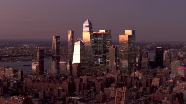 Hudson Yards gökdelenlerini aydınlatan altın güneş ışığının eşsiz bir perspektifinden, Manhattan şehir merkezindeki gökdelenleri ılık ve yumuşak bir ışıkla silip süpürüyor..
