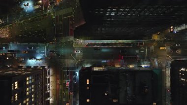 New York 'un aydınlık caddelerinde gece boyunca ilerleyen arabaların hava görüntüsü, aydınlatılmış Manhattan ilçesi çarpıcı bir zemin hazırlıyor..