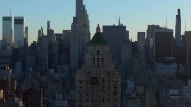 Gündoğumu New York şehrinin ufuk çizgisini sarar ve Midtown Manhattan gökdelenlerinin üzerine sıcak bir ışık saçar. Sabah ışığı şehir manzarasının güzelliğini ön plana çıkarıyor.