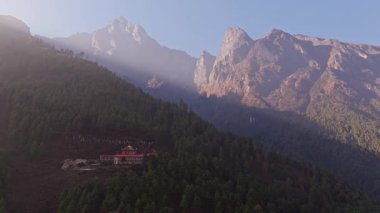 Phakding 'de güneş ışığı banyosu yapan tarihi manastır Nepal' deki sık dağ manzarasının ardında yükselen Himalaya zirveleriyle doludur..