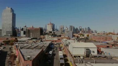 Hava perspektifi Brooklyn 'de endüstriyel bir bölgede çatıları gösteriyor. Manhattan ufuk çizgisi arka planında arabalar aşağıdaki caddede geziniyor..