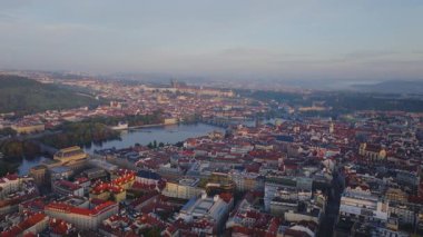 Prag silueti Vltava Nehri 'ni sergiliyor ve çarpıcı bir gündoğumuna karşı ikonik simgeleri vurguluyor. Sağ tarafa bakan bir tava büyüleyici güzelliği gözler önüne seriyor..