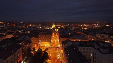Arabalar geceleri Prag 'da işlek bir caddede dolaşırken, canlı şehir ışıkları binaları ve sokakları aydınlatırken, akşamları büyüleyici bir kentsel atmosfer yaratıyor..