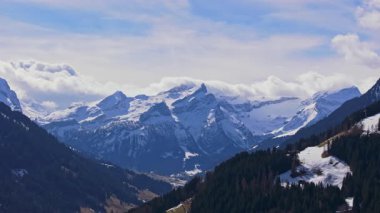 Gstaad yakınlarındaki İsviçre Alp tepelerini ve vadilerini kaplayan karları süpüren üç ayaklı hava manzarası, parlak güneş ışığıyla yıkanmış el değmemiş dağ manzarasını ön plana çıkarıyor..