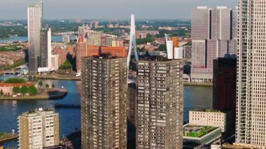 Rotterdam gökdelenleri yüksek binalar, ikonik köprüler ve aşağısı hareketli nehirlerle kaplı. Şehrin dinamik mimarisi ve su yolları.