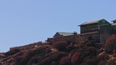 Görkemli Everest Dağı yoğun bulutların arasından yükseliyor, Nepal 'in durgun köyüne bakan karla kaplı tepeleri açığa çıkarıyor..