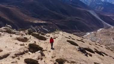 Himalayalar 'da bir dağ yolunda yürüyen yüksek irtifa yürüyüşçülerinin hava görüntüsü, arka planda Everest Dağı, Nepal' de zorlu bir keşif sırasında.