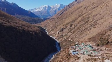 Yükselen Everest zirveleri Nepal vadisinde kıvrılarak yükselen yılanımsı nehirlerin üzerinden Shomare 'ın seyrek bitki örtüsünü ve dağ yerleşimlerini gözler önüne seriyor..