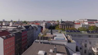 Güneşli bir günde Berlin 'in manzarasını gösteren, bitki örtüsü ve güneş panelleriyle kaplı çatıların havadan görünüşü. Berlin, Almanya 2.2.24