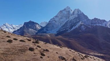 Majestic Ama Dablam dağı, kayalık kayalıkların üzerinde yükseliyor, Nepal 'deki dramatik dağlık arazisiyle el değmemiş Himalaya vahşi doğasını vurguluyor..