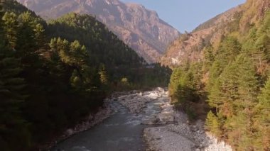 Görkemli Himalaya nehri yemyeşil vadide dolanıp Nepal 'in yukarısındaki engebeli dağlık araziden el değmemiş manzarayı ortaya çıkarıyor..