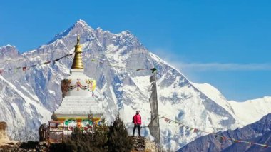 Haşmetli Everest Dağı Budist salağın arkasında yükseliyor, dağcı panoramik Himalaya manzarasına bakıyor, Nepal 'in ruhani dinginliğini ve doğal ihtişamını yakalıyor..
