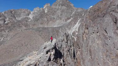 Dağcı Nangkarshang Tepesi 'ndeki kayalık tepede duruyor. Himalaya' nın geniş arazisi. Ama Dablam karlı dağ manzarasına hakim..