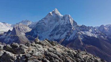 Güneş ışığı, Doğu Nepal 'in Himalayaları' ndaki etkileyici Everest Dağı 'nı aydınlatıyor. Kar kaplı güzelliğini ve kayalık arazisini gözler önüne seriyor..