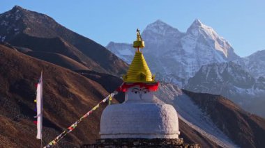 Dingboche 'da parlak güneş ışığı, beyaz Budist stupası, renkli bayraklar sallanıyor, Everest tepesi Solukhumbu Himalaya arka planına karşı yükseliyor..
