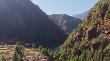 Nepal 'in ücra dağlarında Himalayalar' ın görkemli tepeleriyle çevrili yeşil vadiyi kesen yılan nehri manzarası var..