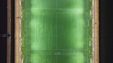 Gece ışıklandırması kuş bakışı futbol maçı, şehir oyuncuları New York 'ta deniz manzarasının yanında yarışıyor.