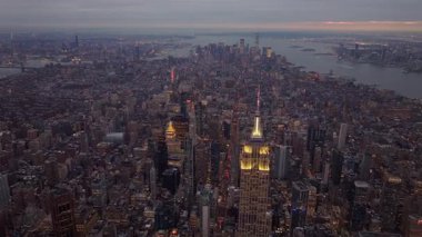 Görkemli Empire State Binası aydınlanmış New York gökdelenleri arasında dikiliyor. Gün batımında nefes kesici bir şehir manzarası yaratıyor..