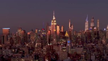 Manhattan 'da gece yarısı gökdelenler, Empire State Binası ve karanlık gökyüzüne karşı kentsel manzarayı aydınlatan bir Vanderbilt gökdelenleri parlıyor..