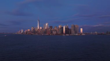 Manhattan 'ın alt ufuk çizgisinin havadan görünüşü, Bir Dünya Ticaret Merkezi, hareketli şehir manzarasının üzerinde altın günbatımı gökyüzüne karşı yükseliyor..