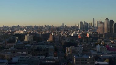 Queens ilçesini aydınlatan altın güneş ışığı beton kanyonlar boyunca dramatik gölgeler uzatıyor mimari ihtişam ve kentsel enerjiyi vurguluyor..