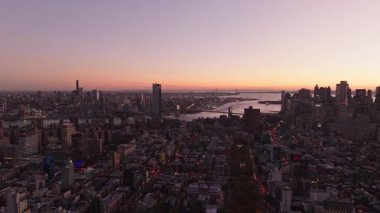 Sıcak ışık, Manhattan 'daki iki köprü, binalar ve sokakları aydınlatmakta ve şehir manzarasına büyüleyici bir hava perspektifi sunmaktadır..