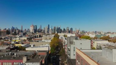 Havadan alınan görüntüler, Brooklyn 'de ikonik Manhattan siluetine karşı Williamsburglar' ın büyüleyici alçak binalarını yakalıyor ve kentsel çevre ve dinamik şehir atmosferini vurguluyor..