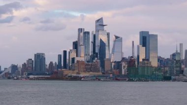 Bulutlu bir akşam, Manhattan 'daki gökdelenlere dramatik gölgeler düşürüyor. Kasvetli atmosferik şehir manzarasına karşı şehir kıyısı siluetlerini ortaya çıkarıyor..