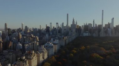 Hava görüntüleri, Central Park 'ta sabah güneşini yakalayıp Manhattan' ın göbeğini aydınlatıyor. Şafak vakti kentsel manzara ve modern mimari gökdelenlerin çarpıcı bir karışımı..