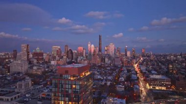 Brooklyn şehir merkezinin ufuk çizgisi gün batımında parlıyor, mimari ızgarayı altın sıcaklığıyla aydınlatıyor, şehir manzarasını değiştiren şehir atmosferini yakalıyor..