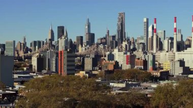 Havadan bakıldığında Roosevelt Adası, Queensboro Köprüsü Manhattan gökdelenini altın sonbahar ağaçları ve geniş mavi ufuk çizgisi ile donatmış..