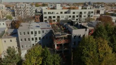 İnşaat işçileri Brooklyn, New York City 'deki bir apartmanın çatısına ek bina kuruyor. Kentsel gelişim ve yerleşim alanlarında devam eden büyüme.