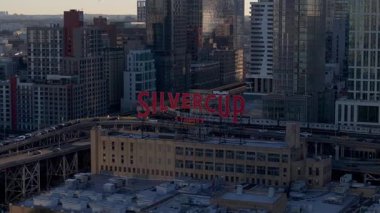 Gün ışığını ısıtan Silvercup Stüdyoları Long Island City, Queens 'teki ikonik çatı tabelası. Şehir trafiği, New York manzarası boyunca yükselen tren..