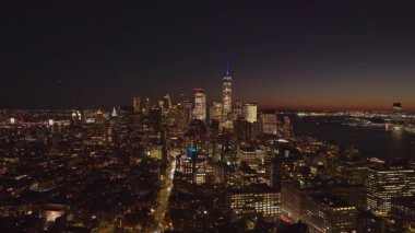 Aydınlatılmış Aşağı Manhattan gökdelenleri alacakaranlıkta parlıyordu, Bir Dünya Ticaret Merkezi New York 'a hakim dramatik mimari gökdelenler akşam saatlerinde.