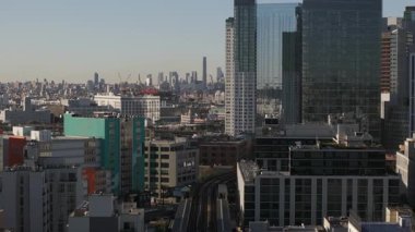 Modern gökdelenleri, konut kulelerini ve yükseltilmiş tren raylarını gösteren New York City silueti, metropoliten mimari çeşitliliği ve kentsel karmaşıklığı vurguluyor.