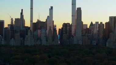 Günbatımında Manhattan şehir merkezindeki gökdelenler Central Park 'ın üzerindeki renkleri ve modern ve klasik gökdelenlerden yapılmış sembolik mimariyi gözler önüne seriyor..