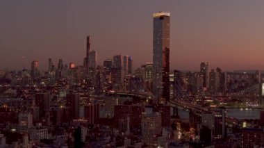Manhattan 'ın İki Köprü Bölgesi' ndeki Manhattan Meydanı yerleşim yeri olan One Manhattan Meydanı 'nı aydınlatan altın güneş ışığı yüksek hava perspektifinden kentsel manzara.