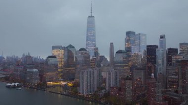 Aydınlatılmış Aşağı Manhattan 'ın havadan görünüşü, Karanlık Şehir ufkuna karşı belirgin bir şekilde duran Bir Dünya Ticaret Merkezi.