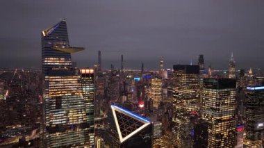 Hudson Yards 'ı aydınlatan gökdelenler Manhattan' ın batı yakasına doğru yayılıyor. Yoğun kentsel manzarayla parlayan gökdelenler..