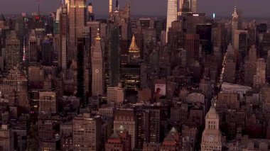 Manhattan şehir merkezindeki gökyüzü alacakaranlıkta parlıyor, Empire State Binası 'nı ele geçiriyor ve yükselen gökdelenler derinleşen akşam ışığına karşı aydınlanıyor..